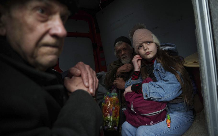 A family sit inside a van in Ukraine during an evacuation.