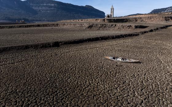 FILE - An abandoned kayak lies on the cracked ground at the Sau reservoir, which is only at 5 percent of its capacity, in Vilanova de Sau, about 100 km (62 miles) north of Barcelona, Spain, Friday, Jan. 26, 2024. (AP Photo/Emilio Morenatti, File)