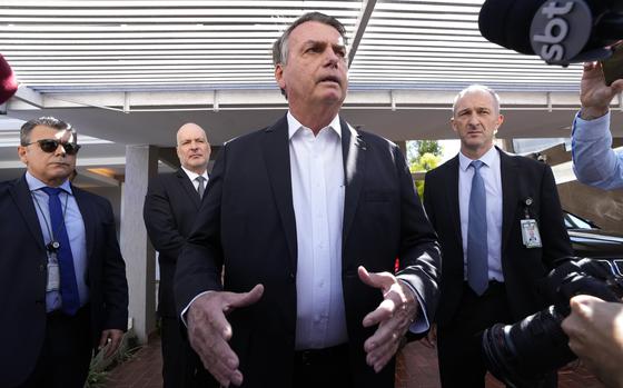 Former Brazilian President Jair Bolsonaro speaks to the press outside his home in Brasilia in May 2023 after Federal Police agents carried out a search and seizure warrant.