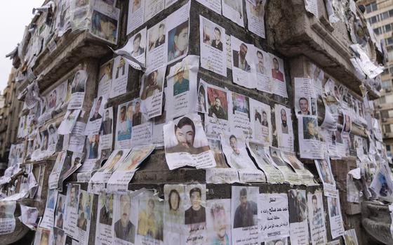 Portraits of missing people whose families say they were taken by the Assad regime are plastered across a monument in Damascus, Syria, Saturday, Dec. 28, 2024 (AP Photo/Mosa'ab Elshamy)