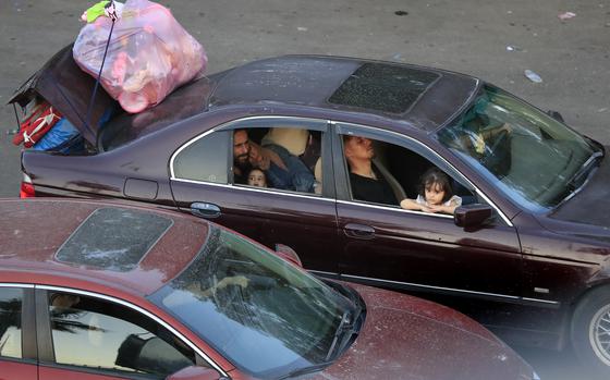 Lebanese citizens who fled the southern villages amid ongoing Israeli airstrikes Monday, sit in their cars at a highway that links to Beirut city, in the southern port city of Sidon, Lebanon, Tuesday, Sept. 24, 2024. (AP Photo/Mohammed Zaatari)