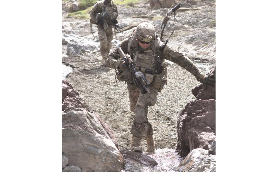 Sgt. Joshua Sutherland, in the foreground, and Pfc. Alex Bolden hike up a stream bed 