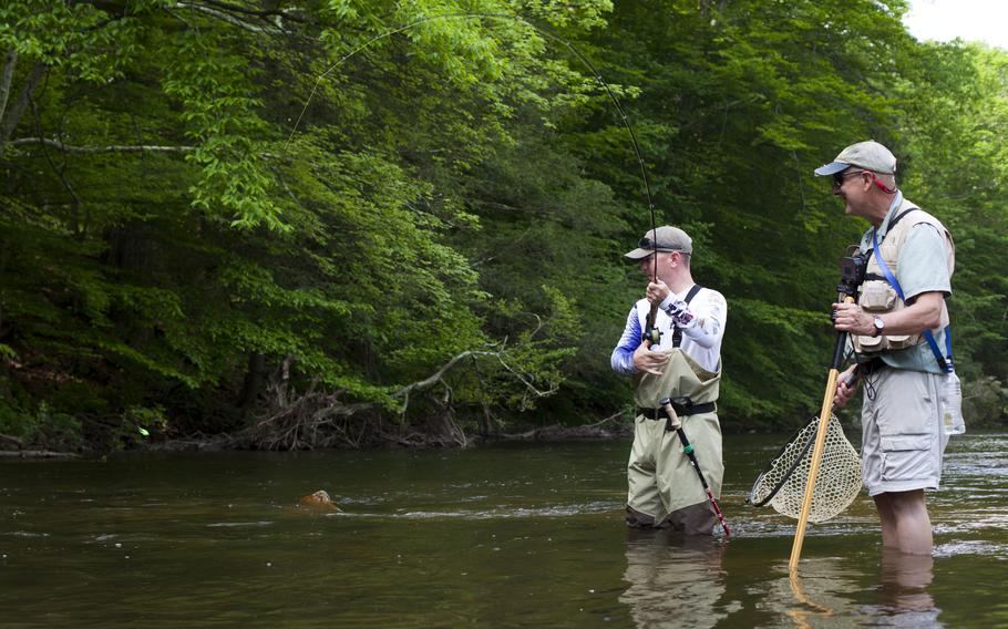 U.S. Marine Corps Staff Sgt. Bradley Wells, left, with Special Purpose Marine Air-Ground Task Force Fleet Week New York, reels in a trout