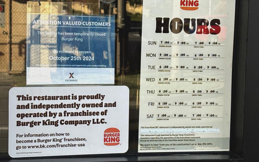 Signs posted to the door of a Burger King restaurant explain hours of operation.