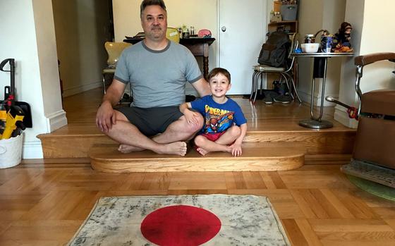 Scott Stein and his son, Nicholas, pose with a Japanese flag his grandfather, Bernard Stein, brought home after serving in the Philippines during World War II. 