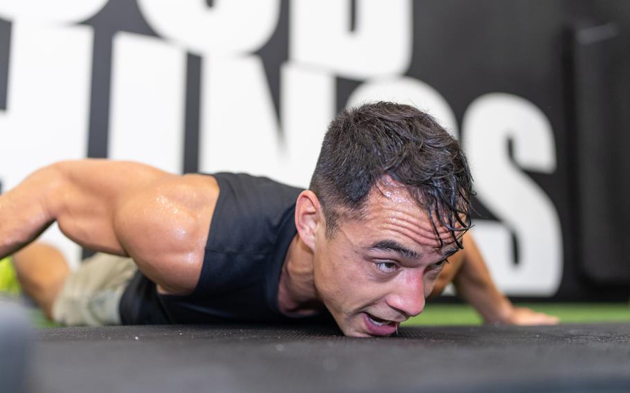 A soldier performs a burpee in a push-up position.