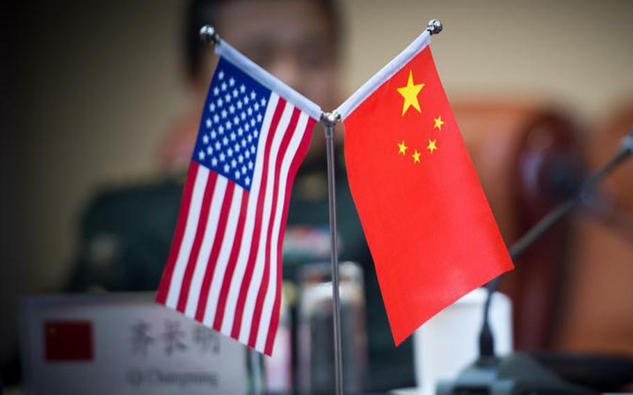 Small U.S. and Chinese flags on desk.