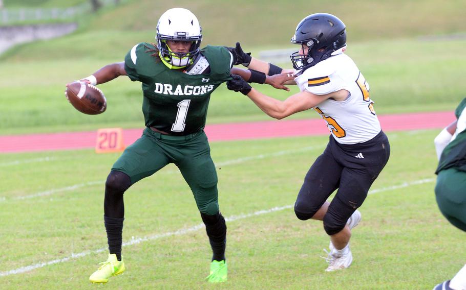 Kubasaki quarterback Carlos Cadet defends against the tackle of ASIJ's Michael Piscopo. Cadet had 213 yards and four touchdowns on offense for the Dragons.