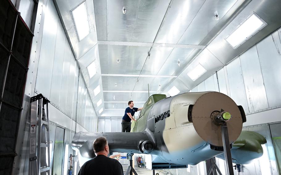 Project lead Tony Hare, bottom left, with museum specialist Jay Flanagan, who is removing paper from the IL-2. 