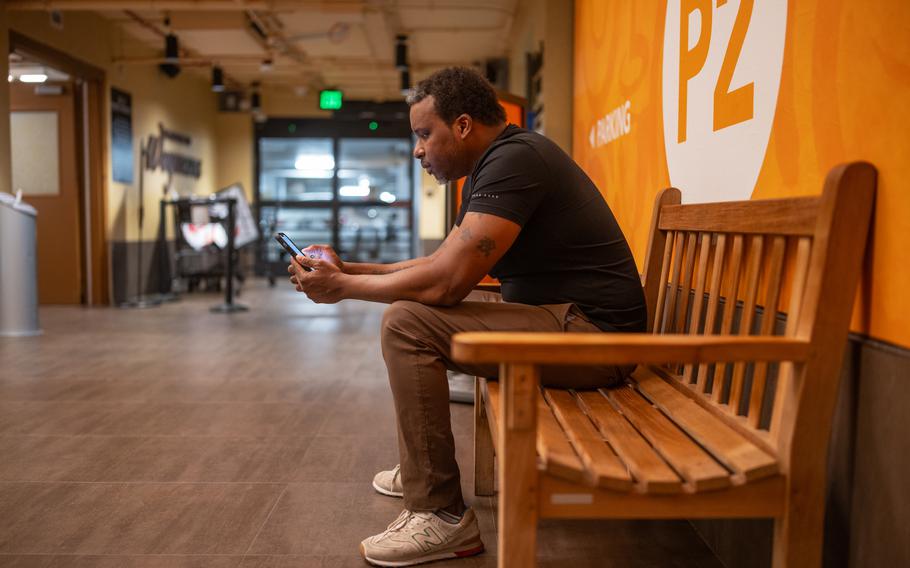 Larry Askew, who has been working for Instacart since August 2022, watches his phone for delivery orders. He also delivers for UberEats. 