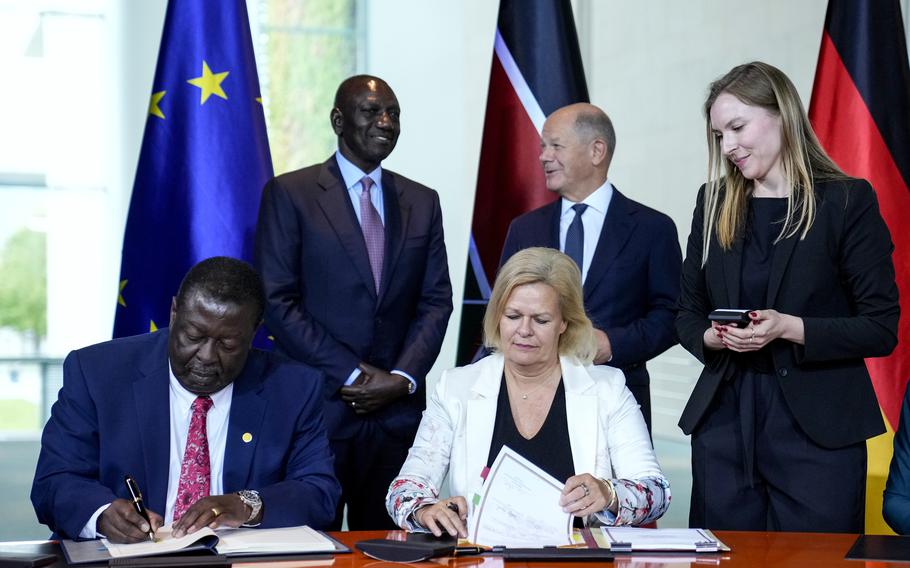 German Interior Minister Nancy Faeser, down right, signs a migration agreement with Kenyan’s Prime Cabinet Secretary Musalia Mudavadi, left, as German Chancellor Olaf Scholz, centre behind, and Kenyan President William Ruto, left behind, at the chancellery in Berlin