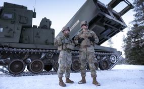 Army Sgt. Makayla Sodergren, a crew chief, and Sgt. Johnathan Welch, a gunner, both with 1st Battalion, 6th Field Artillery Regiment, show off their Multiple Launch Rocket System during exercise Dynamic Front in Rovajavri, Finland on Nov. 20, 2024.