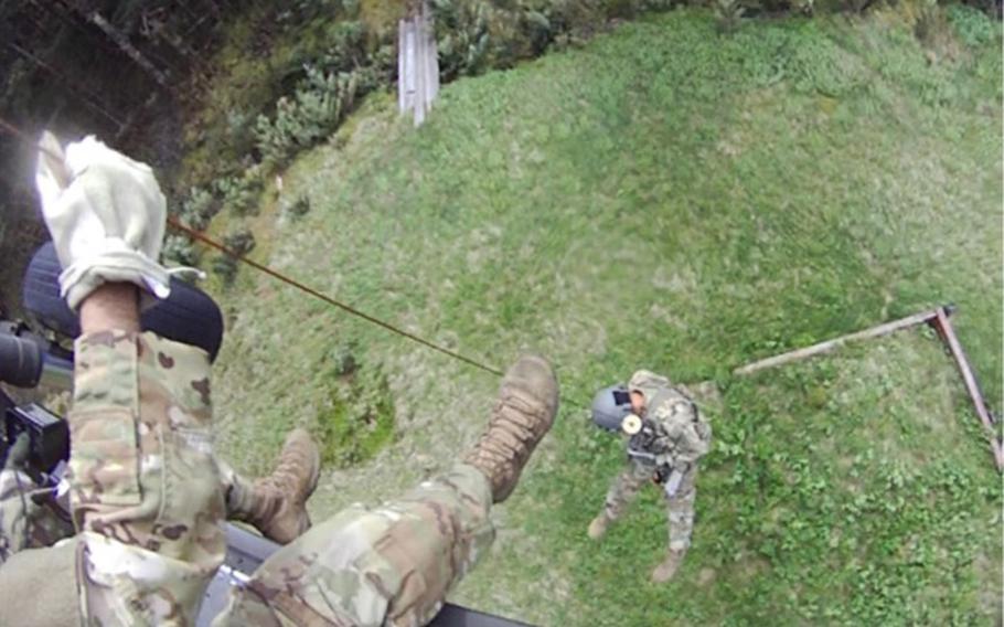 Tennessee Army National Guard Black Hawk helicopter crew chief Sgt. Daniel Bandy lowers flight paramedic Sgt. 1st Class Nolan Ogle to begin rescuing a hiker in respiratory distress in Great Smoky Mountain National Park on May 31, 2024. 