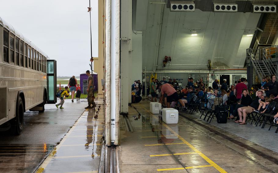 Outbound airmen and their families are transported to a hangar serving as a temporary passenger terminal at Andersen Air Force Base, Guam, on May 30, 2023. The regular terminal was significantly damaged by Typhoon Mawar.