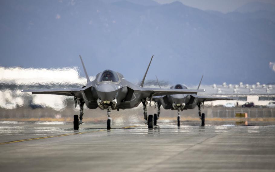 Two F-35 B fighters taxi on a runway.