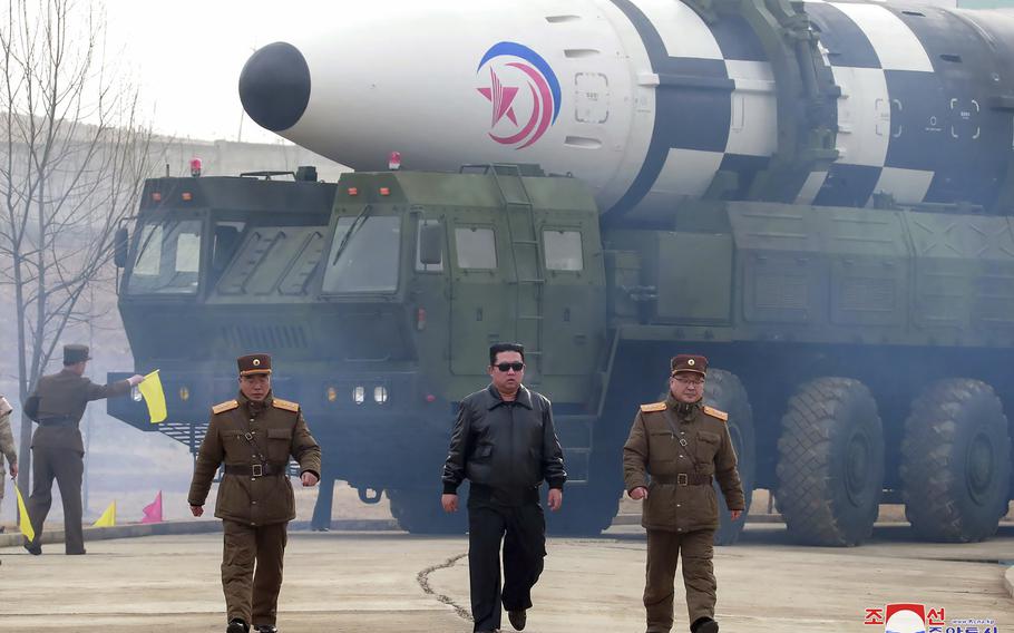 Kim Jong Un walks near what it says is a Hwasong-17 intercontinental ballistic missile on the launcher.