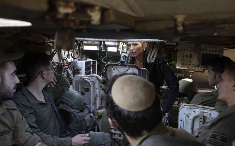 Military reservist Lia Golan, 24, gives instructions to Israeli soldiers atop a Tiran tank on the Israel-Gaza border in December. Golan, a reserve tank instructor and student at Tel Aviv University, says she is troubled by the toll the uncertainty of the Gaza war is taking.