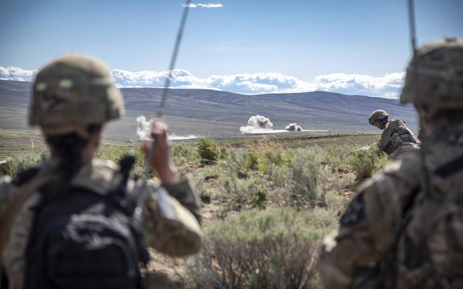 U.S. Army soldiers observe artillery rounds hit their objective during an exercise at Yakima Training Center.