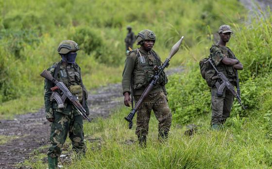 FILE - M23 rebels stand with their weapons in Kibumba, in the eastern of Democratic Republic of Congo, Dec. 23, 2022. (AP Photo/Moses Sawasawa, File)