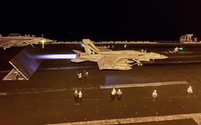 A Navy jet prepares to take off from an aircraft carrier.