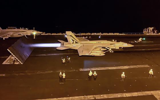 A Navy jet prepares to take off from an aircraft carrier.