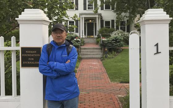 In this photo provided by the Dong family, Chinese journalist Dong Yuyu stands at the gates of the Nieman Foundation for Journalism at Harvard University in Cambridge, Mass., in May 2017. (Courtesy Dong Family via AP)