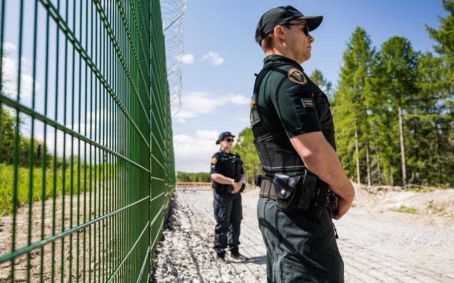 Finnish border guards at a section of the initial 3-kilometer (1.9-mile) stretch of fence under construction near a border crossing near Imatra, in southeast Finland, on May 30, 2023. 