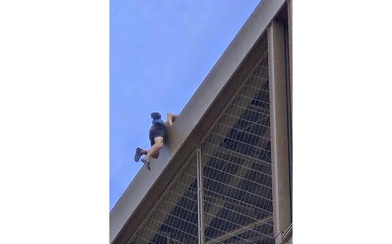 In this photo provided by Nickey Worlock, a man climbs the Eiffel Tower, during the 2024 Summer Olympics, Sunday, Aug. 11, 2024, in Paris. 