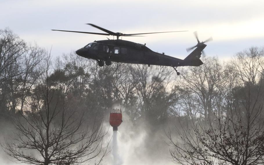 U.S. Army soldiers use Blackhawk helicopters to assist with wildfire containment.