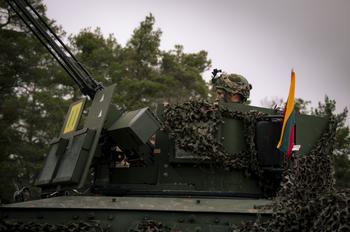 A Lithuanian soldier sits in the turret of an M577 armored personnel carrier.