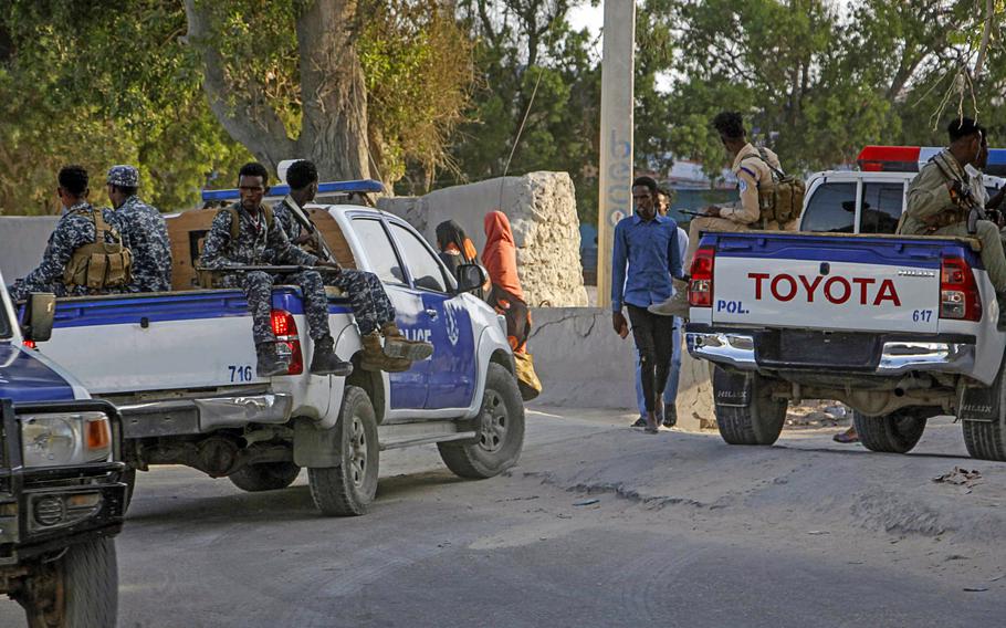 Somalia police patrol sitting on trucks outside