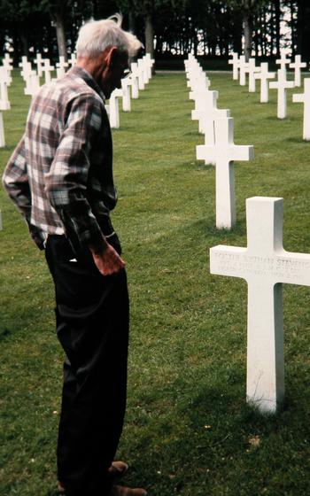 Jim Scarbrough stands in front of the crosses marking graves.