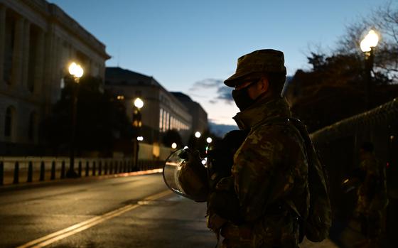 A National Guard member holds his riot gear near the U.S. Capitol Building Jan. 20, 2021, in Washington. A U.S. Army soldier has been arrested in Hawaii on charges that he repeatedly struck a police officer with a flagpole during a mob’s attack on the U.S. Capitol more than three years ago.