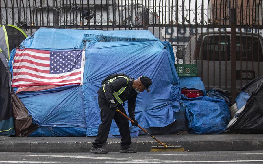 Urban Alchemy practitioner Barney Hines Jr., 56, is cleaning the gutters in skid row on May 13, 2021, in Los Angeles, California. 