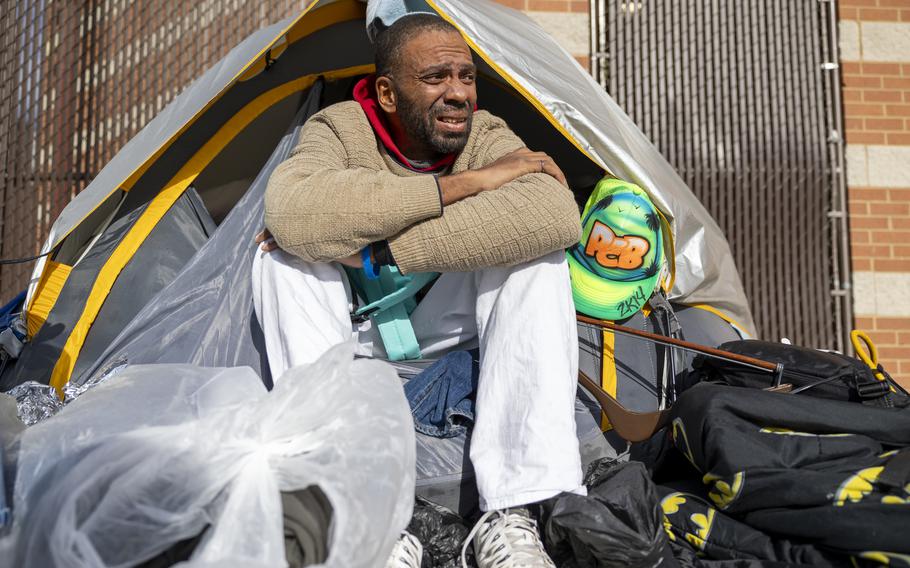 Homeless veteran sits outside a makeshift tent.