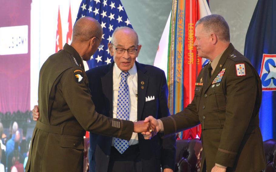 A photo of Gen. Charles Hamilton, commander for the Army Material Command, embraces retired Lt. Gen. Arthur Gregg and Maj. Gen. Mark Simerly, commander for the Combined Arms Support Command.