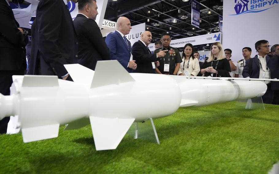 Philippine military chief Gen. Romeo Brawner Jr. center, listens as an exhibitor explains the Wind Demon, a long range air to surface cruise missile, during the Asian Defense and Security Exhibition on Wednesday, Sept. 25, 2024, in Manila, Philippines.