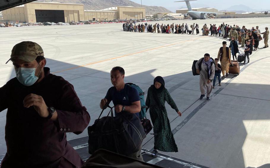 Afghan and American evacuees board a C-17 Globemaster III at the Kabul International Airport.