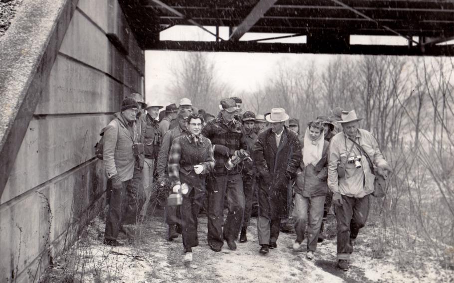 The C&O Canal troupe, pushing on through a blinding snowstorm, passes beneath a Western Maryland Railroad trestle on March 21, 1954. Justice William O. Douglas is on the right.