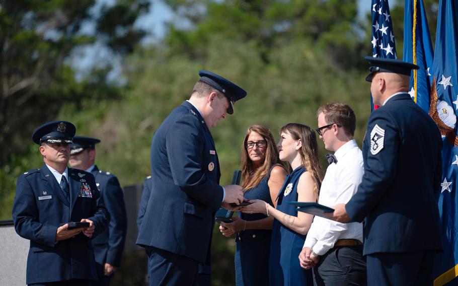 U.S. Air Force Lt. Gen. Tony Bauernfeind, commander of Air Force Special Operations Command, presents the Distinguished Flying Cross to the family of U.S. Air Force Maj. Randell Voas, a CV-22B Osprey pilot, on his behalf at the Voas-Lackey Roundabout at Hurlburt Field, Florida, May 16, 2024. Voas posthumously received the DFC for actions taken during a combat mission near Qalat, Afghanistan, April 9, 2010. 