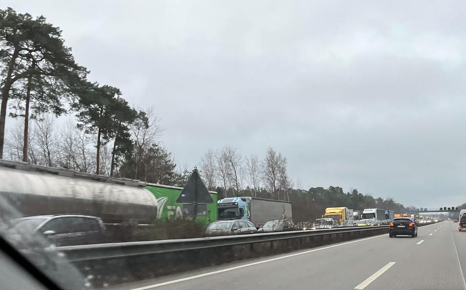 Trucks and cars sit in traffic on the highway