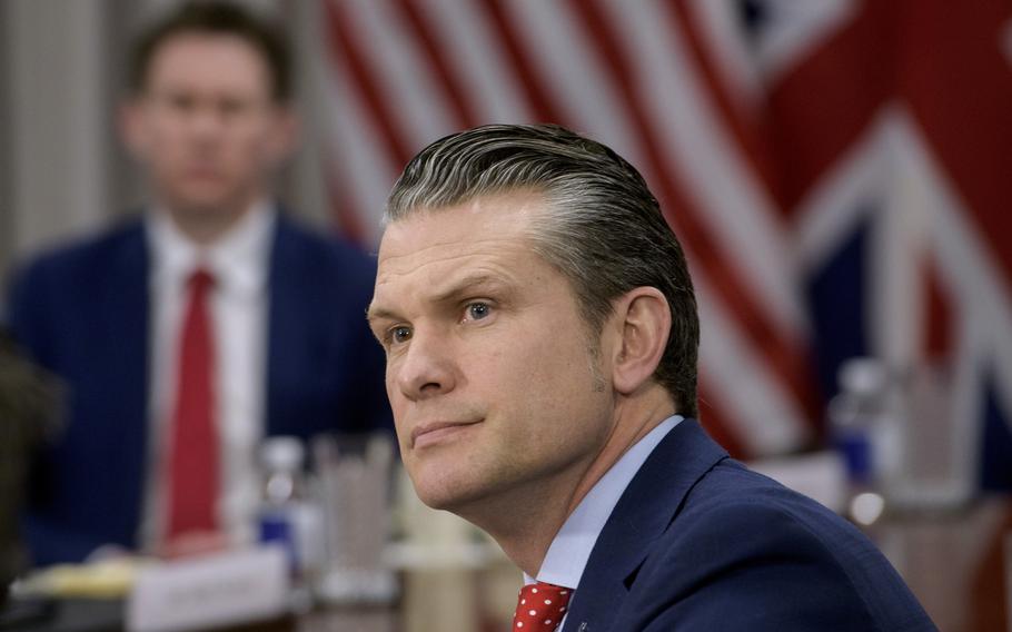 Pete Hegseth sits at a meeting.