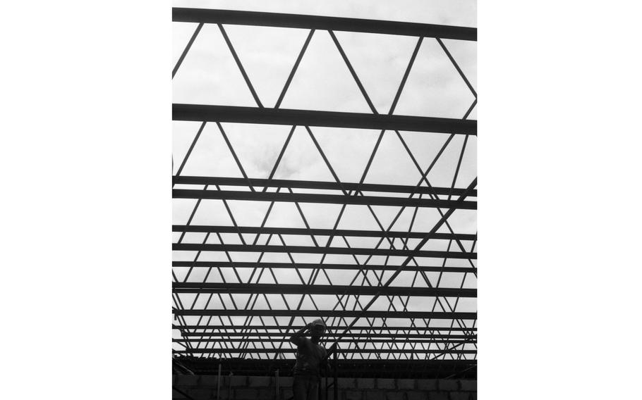 A construction worker is silhouetted as he works on a building