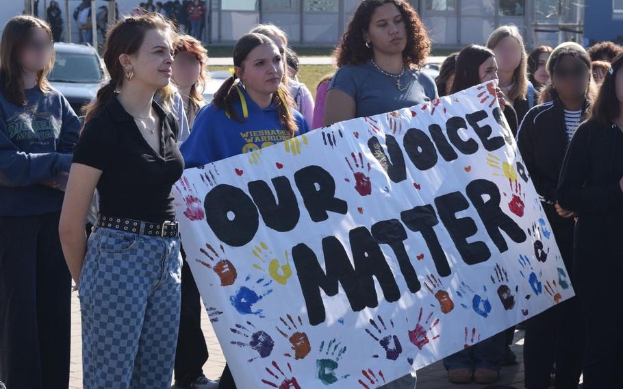 Students hold up protest signs