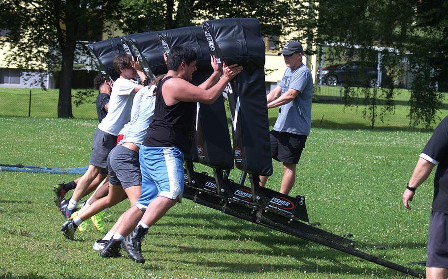 Players from Vilseck's football team lift head coach Eric Mead as they push the school's brand new sled during the first practice of the year in Vilseck, Germany, on Monday, Aug. 5, 2024.