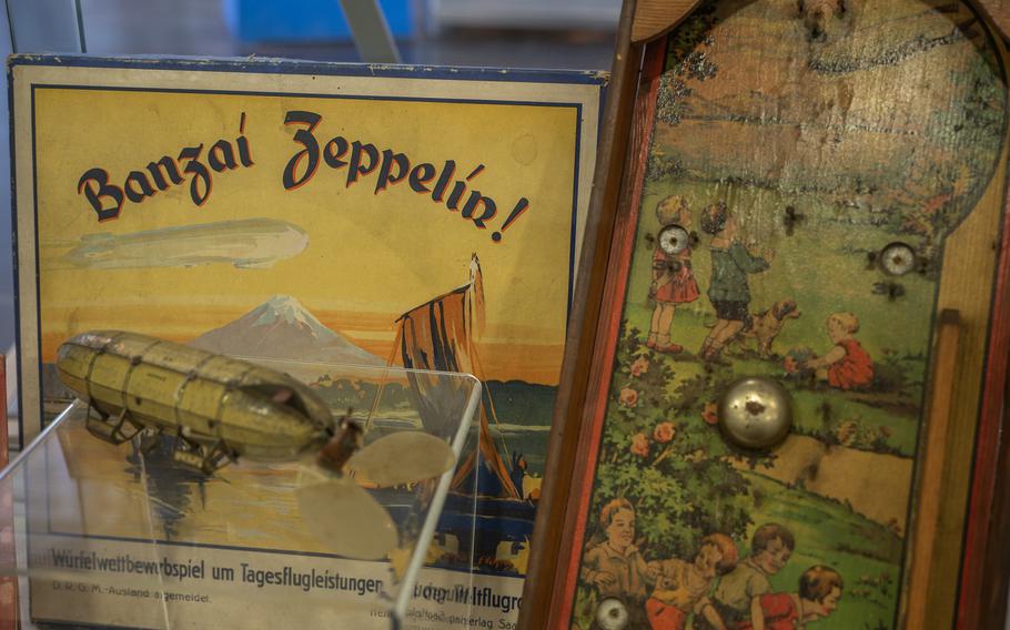 Memorabilia at the Zeppelin Museum in Neu-Isenberg, Germany, includes this image painted on wood and the board game Banzai Zeppelin, which was inspired by the Graf Zeppelin's round-the-world journey in 1929.