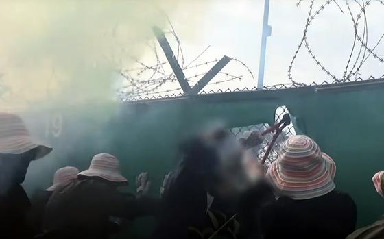 A group of protesters carrying Palestinian flags and wearing black ran up to the gate at Caserma Del Din in Vicenza, Italy, Sept. 8, 2024, as seen in this screenshot from YouTube, and  began cutting the wire of the fence. The garrison public works department repaired the fence the same afternoon. 