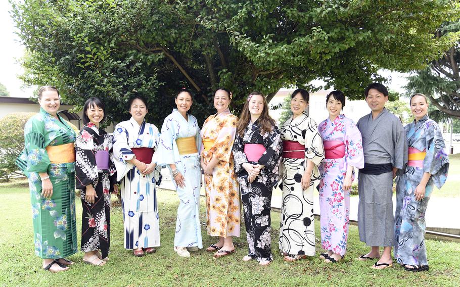 Americans and Japanese pose wearing yukata, unlined summer kimonos, during a cultural exchange at the USO on Yokota Air Base, Japan, July 22, 2023. 