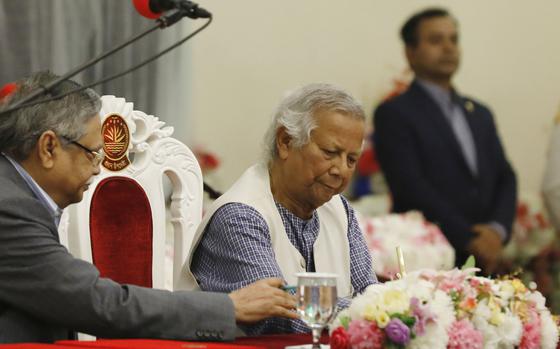 Nobel laureate Muhammad Yunus signs a document after taking the oath of office as the head of Bangladesh's interim government, in Dhaka, Bangladesh, Thursday, Aug. 8, 2024. (AP Photo/Rajib Dhar)