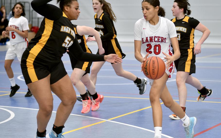 Lakenheath's A'Lydia McNeal picks up the ball while driving as Stuttgart's Icsiss Perez defends during pool play of the Division I DODEA European Basketball Championships on Thursday at Ramstein High School on Ramstein Air Base, Germany.